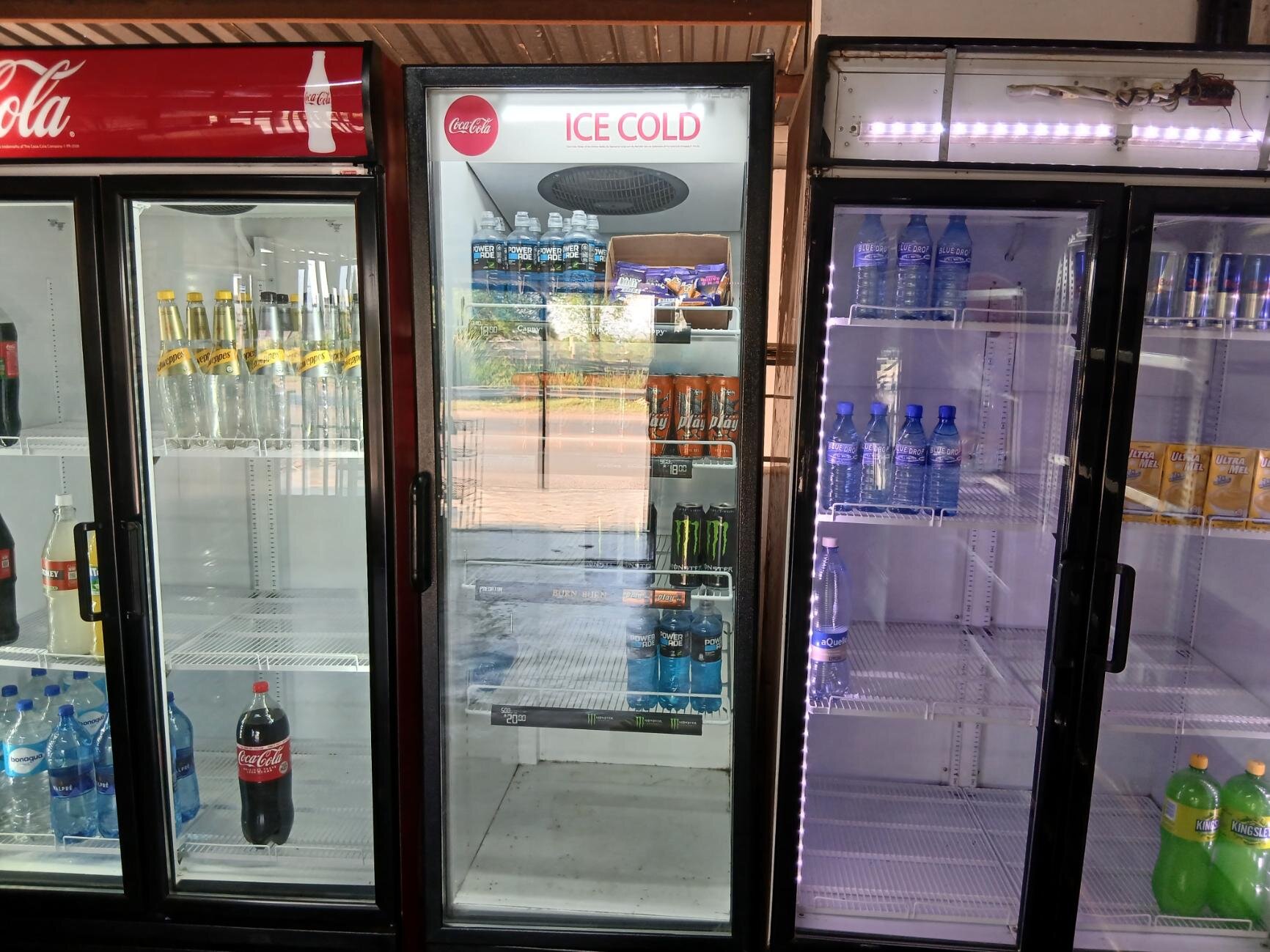 Multiple refrigerated cabinets stocked with cooldrinks and energy drinks